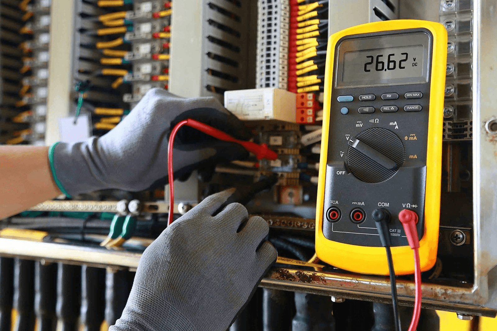 Licensed On Time electrician testing a live panel with a multimeter